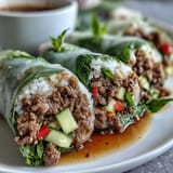 Close-up of one sliced Thai Basil Beef Roll, revealing the savory beef, fresh Thai basil, and colorful vegetables wrapped in soft rice paper.