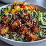 Golden-brown crispy baked tofu cubes and spiralized zucchini carrots top fluffy quinoa in an Easy Teriyaki Bowl.