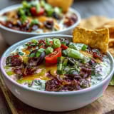 Festive Easy Taco Dip Cups featuring creamy taco-seasoned layers, fresh lettuce, diced tomatoes, and black olives, perfect for party appetizers.