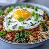 Vibrant kimchi fried rice bowl, colorful with carrots and green onions.