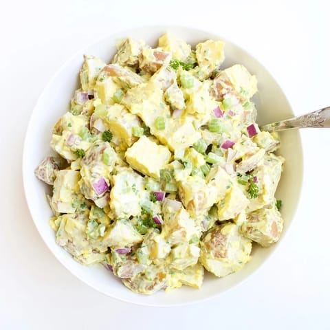 Vibrant bowl of homemade Potato Salad featuring fork-tender Yukon Gold potatoes tossed in a tangy dressing, perfect for picnics, potlucks, and serving chilled alongside grilled burgers or chicken.