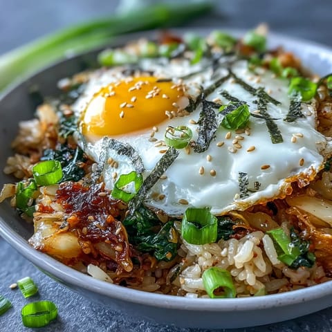 Spicy fermented cabbage kimchi fried rice bowl, topped with a sunny-side-up egg.