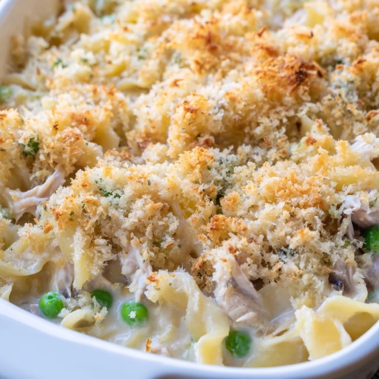 A hearty scoop of homemade Tuna Casserole served alongside a fresh garden salad.