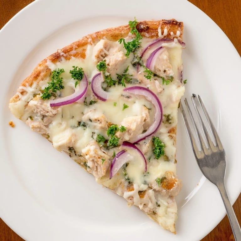 Freshly baked Chicken Alfredo Pizza garnished with parsley and ready to serve hot.