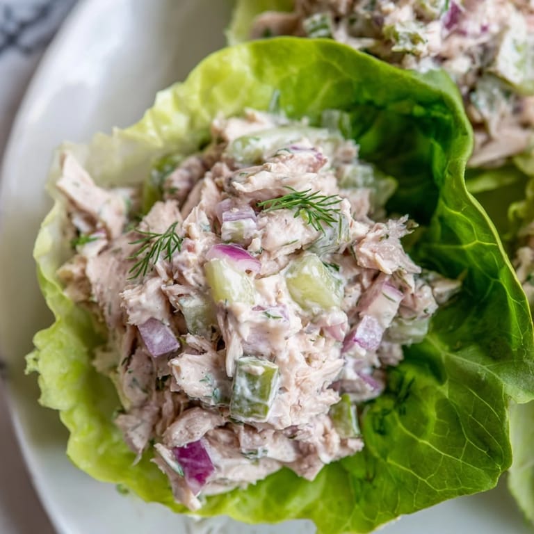 A close-up of Dill Pickle Chicken Salad Lettuce Cups showcasing the creamy dressing and vibrant dill garnish.