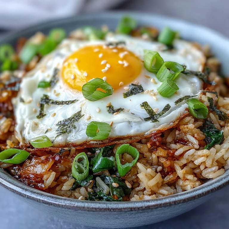 Vibrant kimchi fried rice bowl, colorful with carrots and green onions.