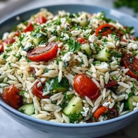 Vibrant summer orzo salad with feta, lemon, and fresh herbs, ready to serve.